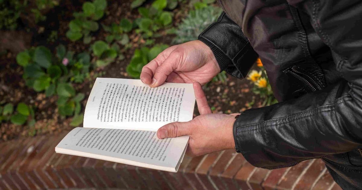 Foto de un hombre leyendo un libro en un espacio abierto en Bogotá.