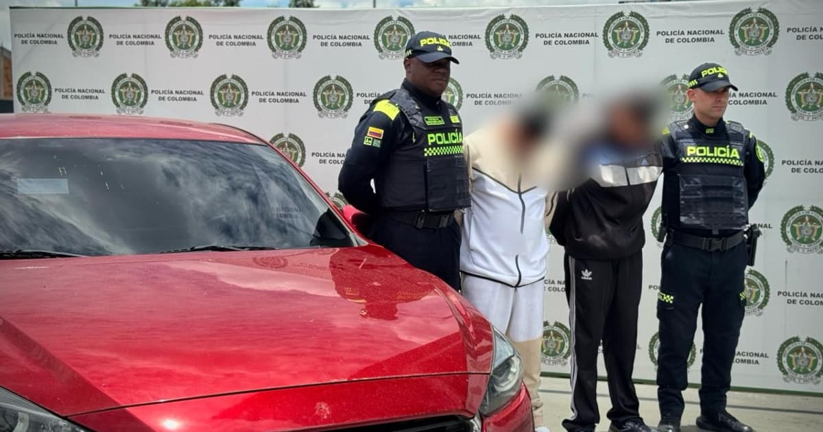 Foto del vehículo rojo y los dos hombres capturados tras operativo de la Policía de Bogotá.