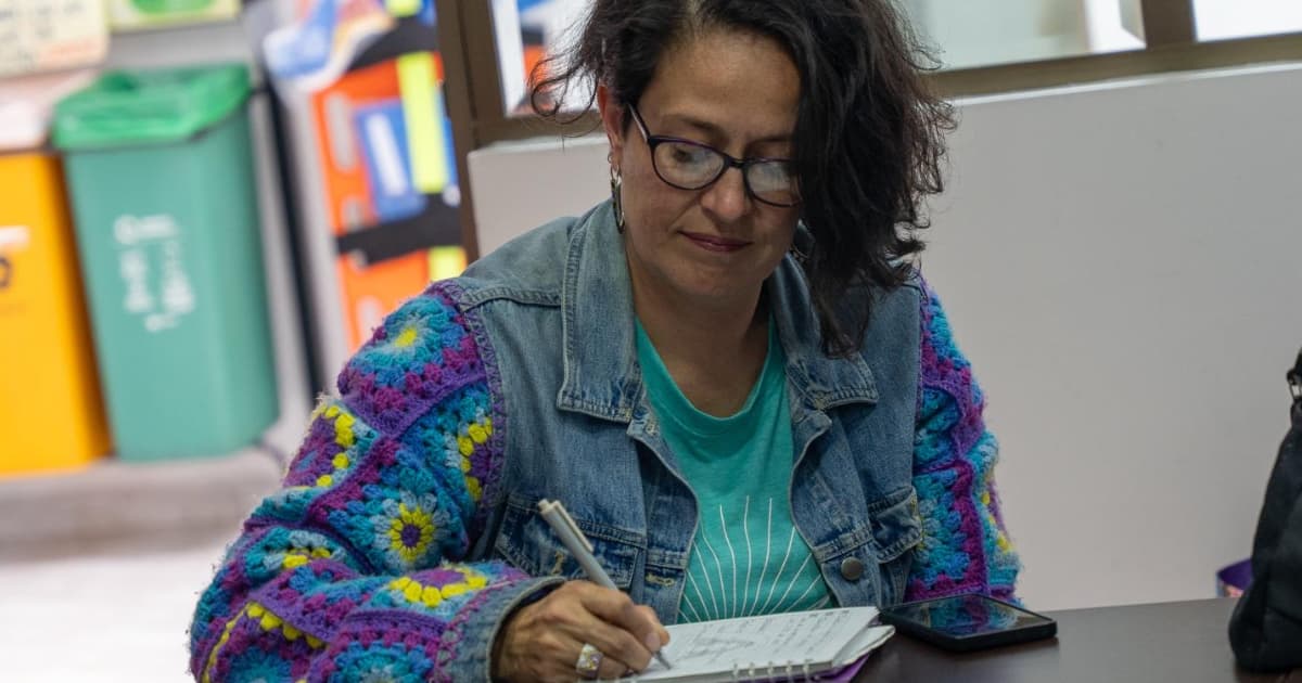 Mujer tomando nota en un cuaderno.