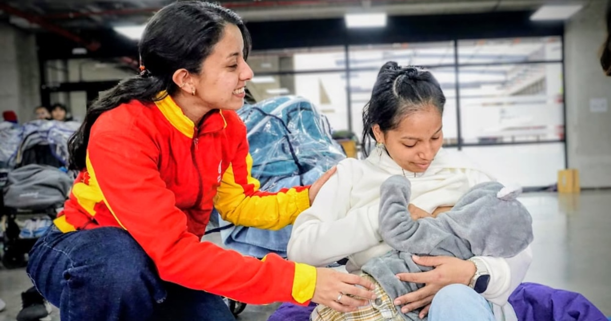 Imagen de una funcionaria con una madre que carga a su bebé