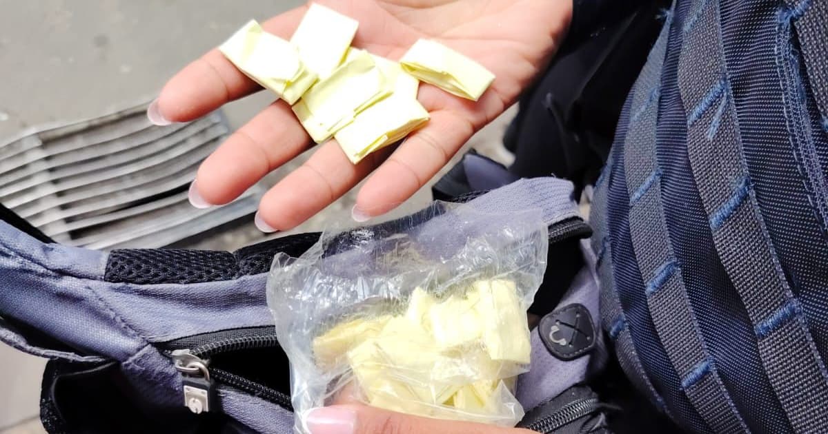 Mujer sosteniendo dosis de droga en sus manos