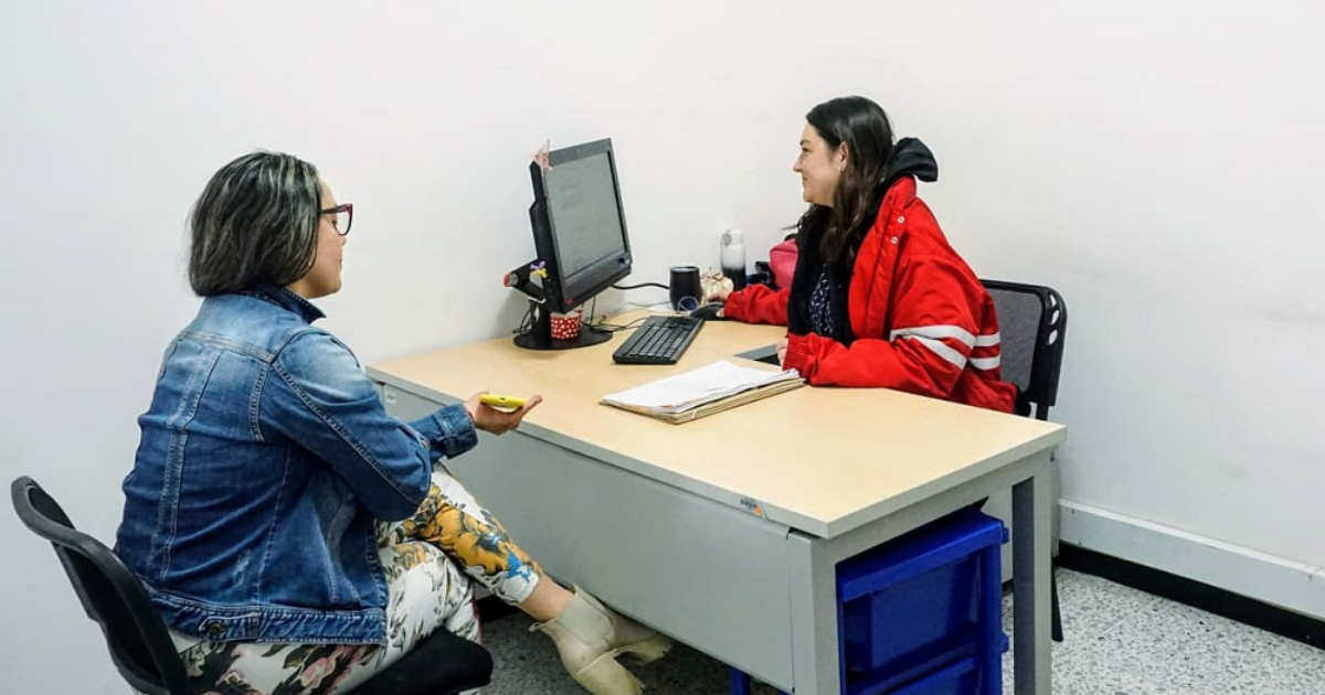 Imagen de una funcionaria atendiendo a una mujer 