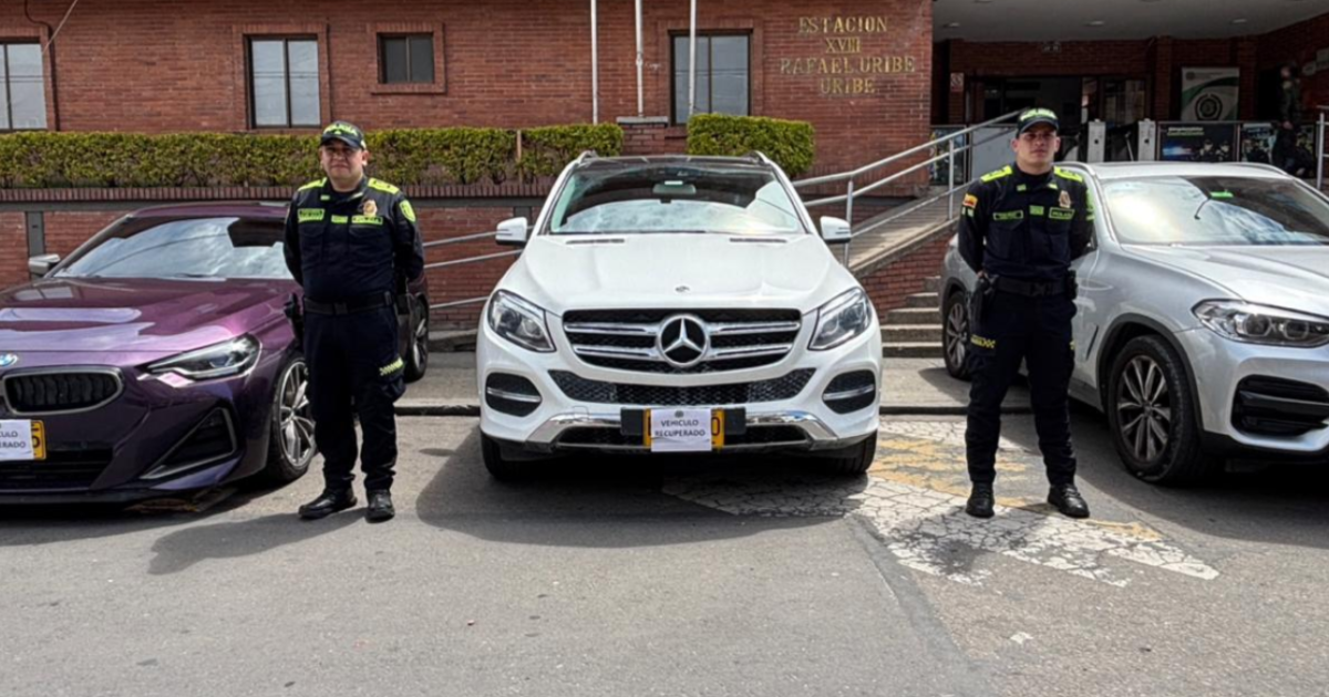Imagen de dos policías junto a los vehículos recuperados
