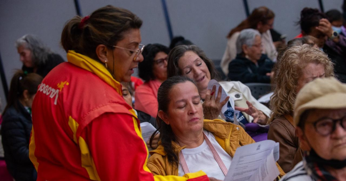 Imagen de una funcionaria pública hablando con una señora de la comunidad