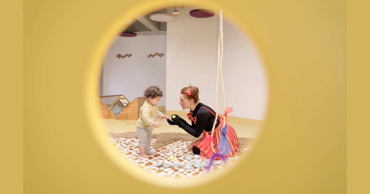 Imagen de una muer con una niña de la primera infancia disfrutando de las actividades.