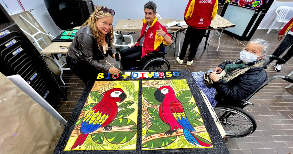 Imagen de personas con discapacidad al lado de un cuadro