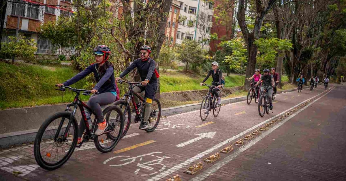Foto de bogotanos y bogotanas usando bicicleta y circulando por una ciclorruta en Bogotá.