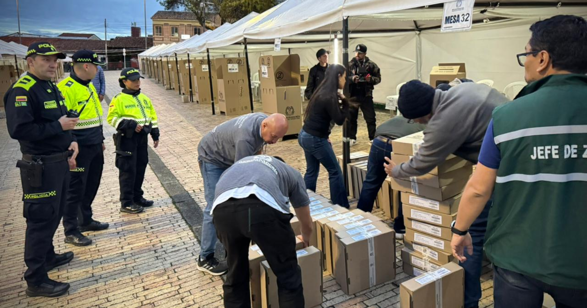 Imagen de personas alistando mesas de votación