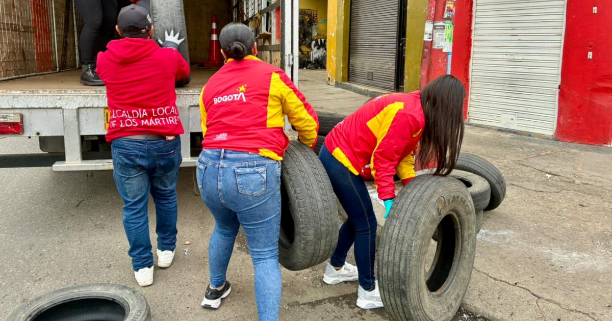 Imagen de funcionarias públicas recogiendo llantas