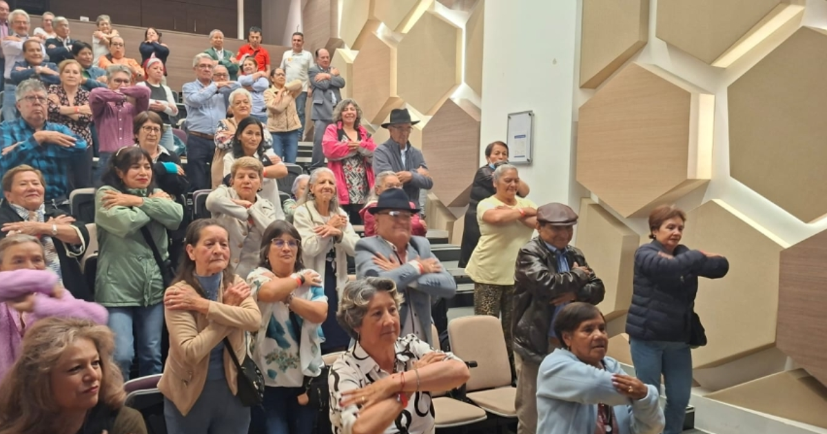 Foto de un grupo de adultos mayores en un auditorio