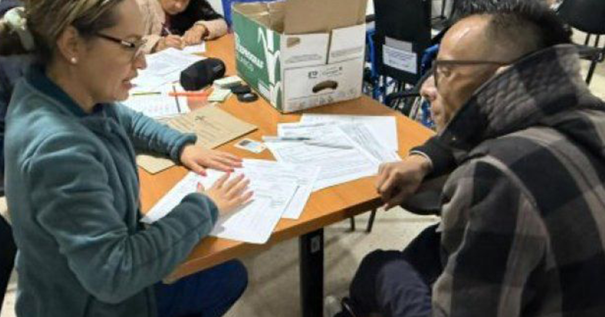 Imagen de una funcionaria hablando con una persona con discapacidad