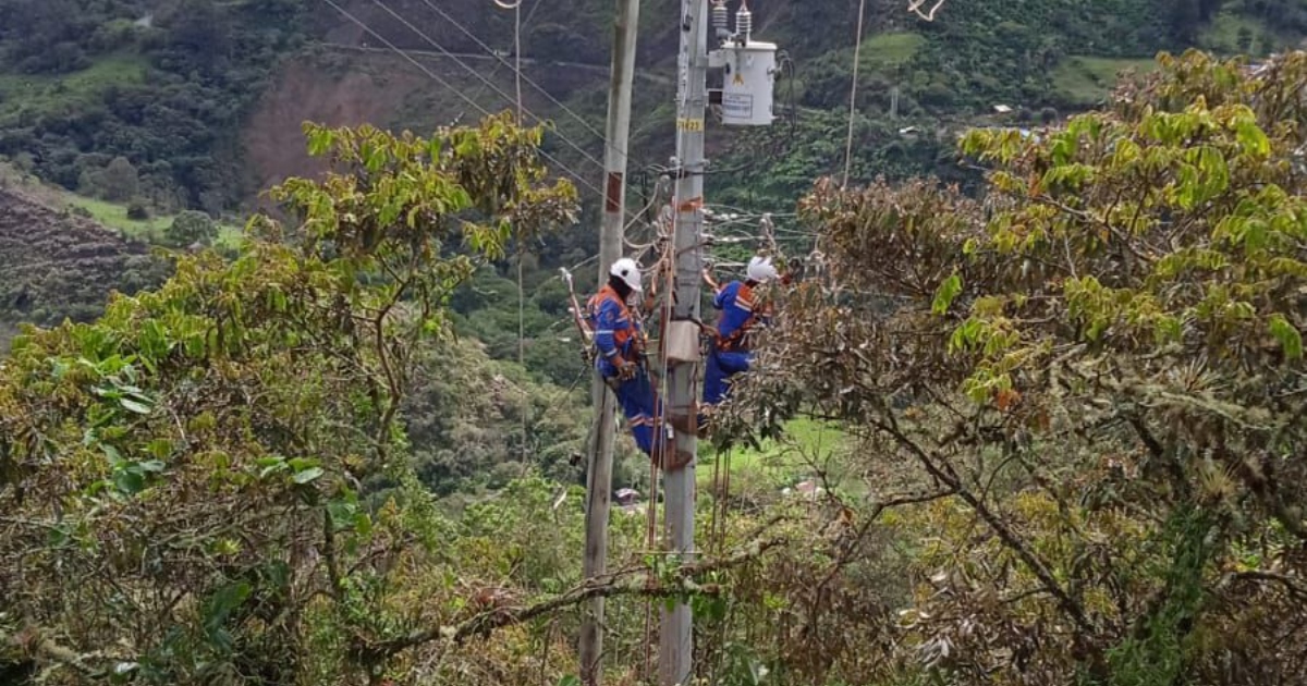 Foto que muestra dos personas con el uniforme de Enel Colombia en un poste de energía