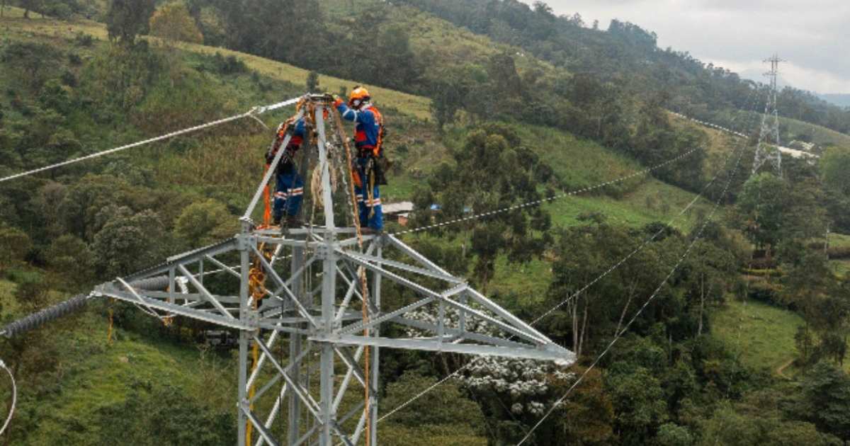 Foto que muestra dos personas con el uniforme de Enel Colombia realizando labores en una antena de energía
