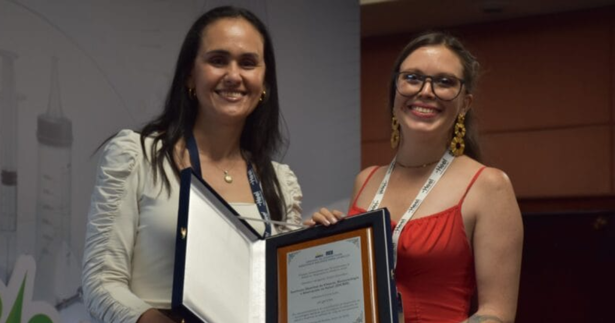 Foto de dos mujeres con un reconocimiento 