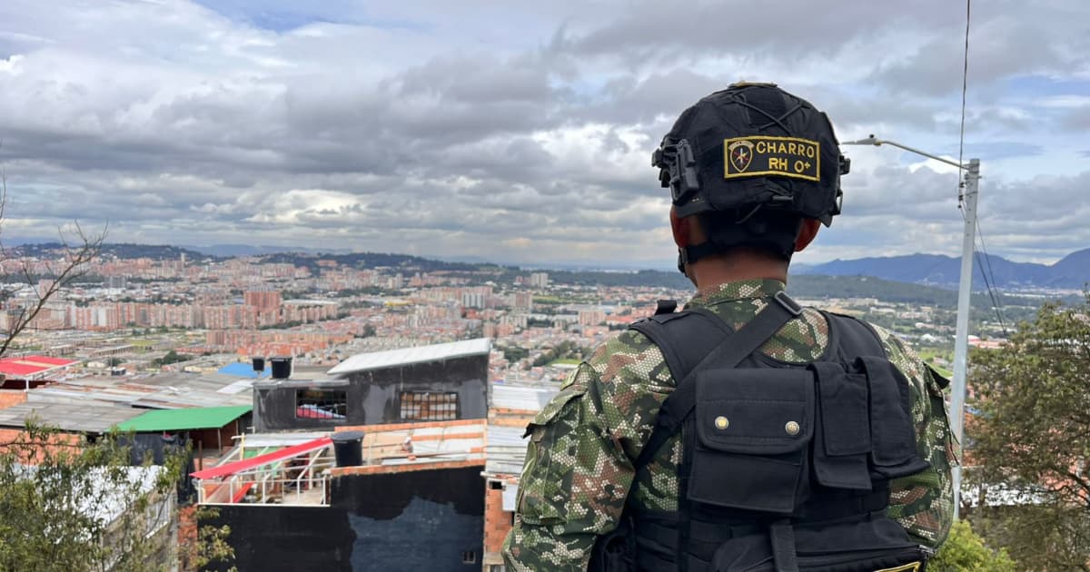 Militar mirando vista del sur de Bogotá en el horizonte.