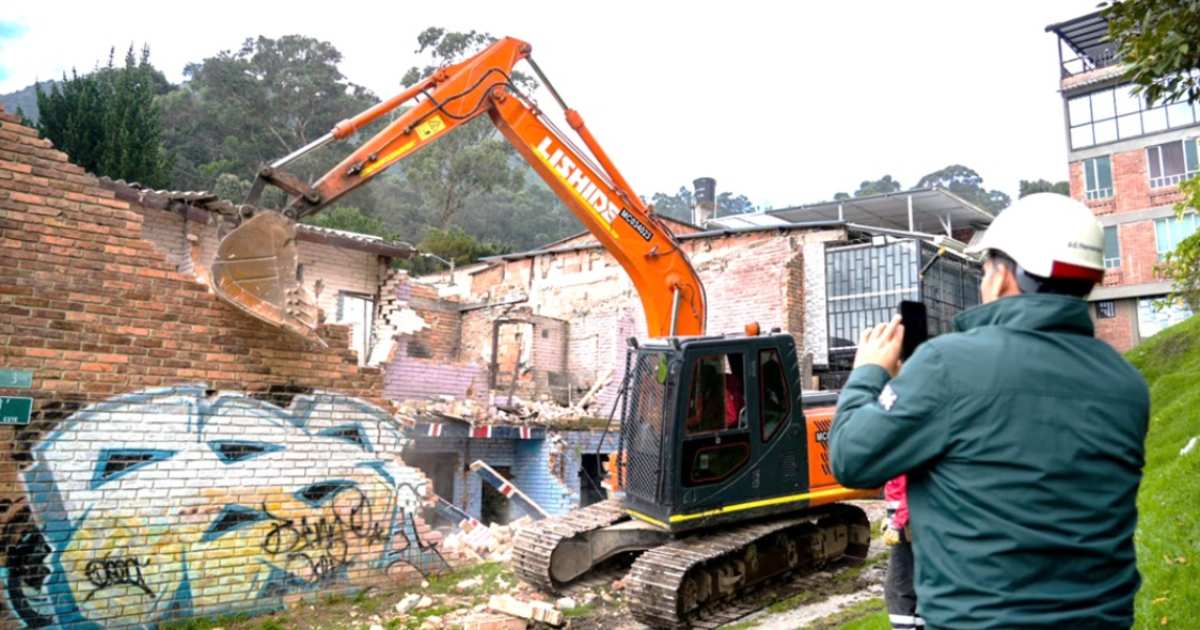 Foto que muestra una retroexcavadora tumbando una casa 