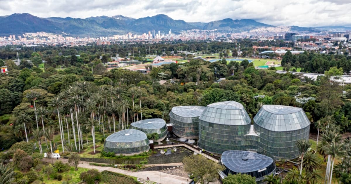 Imagen panorámica del Tropicario del Jardín Botánico de Bogotá José Celestino Mutis con vista a la ciudad, cerros y cielo nublado.