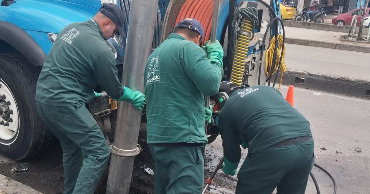 Foto que muestra tres personas con el uniforme del Acueducto de Bogotá
