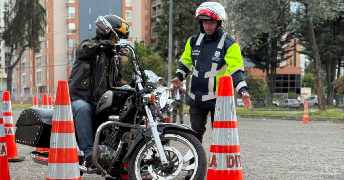 Foto de un motociclista y un funcionario de Movilidad 