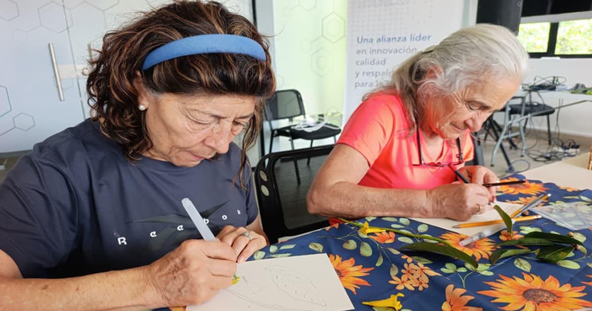 Mujeres mayores de Bogotá dibujan hojas sobre mesa con plantas y materiales