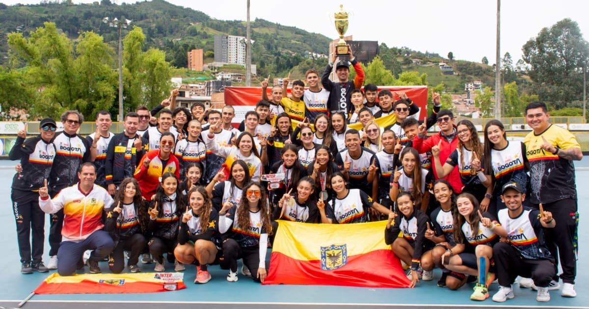Equipo Bogotá celebra campeonato de patinaje con trofeo y bandera en pista