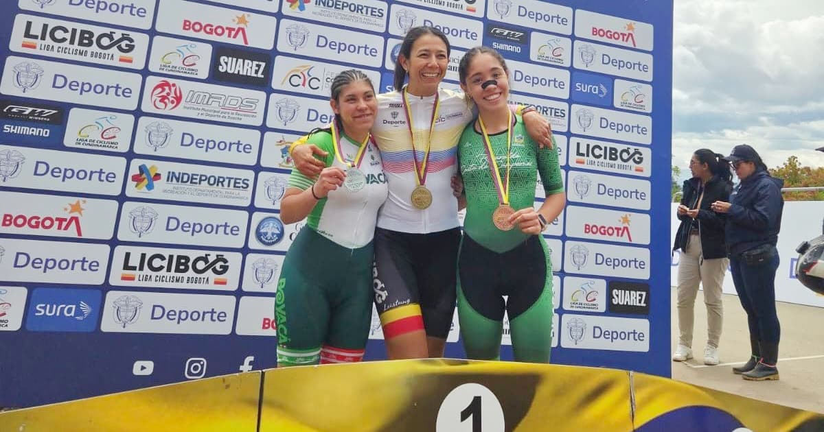 Atletas del Equipo Bogotá celebran en podio con medallas frente a panel del Campeonato Nacional de Paracycling Pista y Ruta