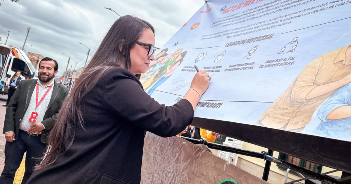Foto de una mujer firmando una pancarta 