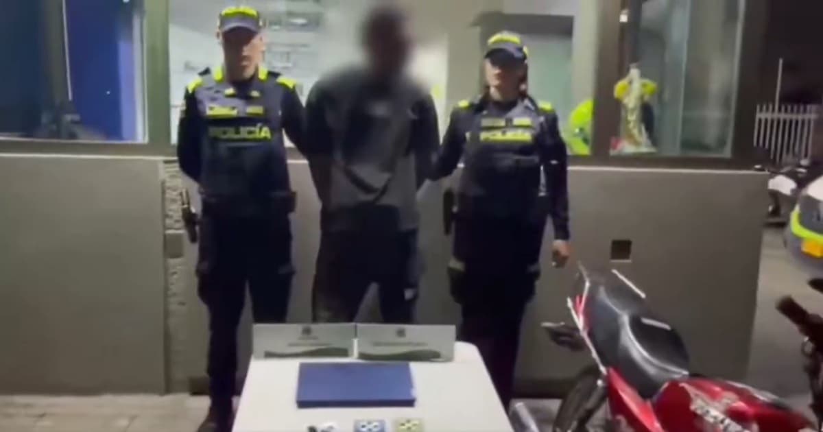 Foto de un delincuente capturado junto a dos uniformados.