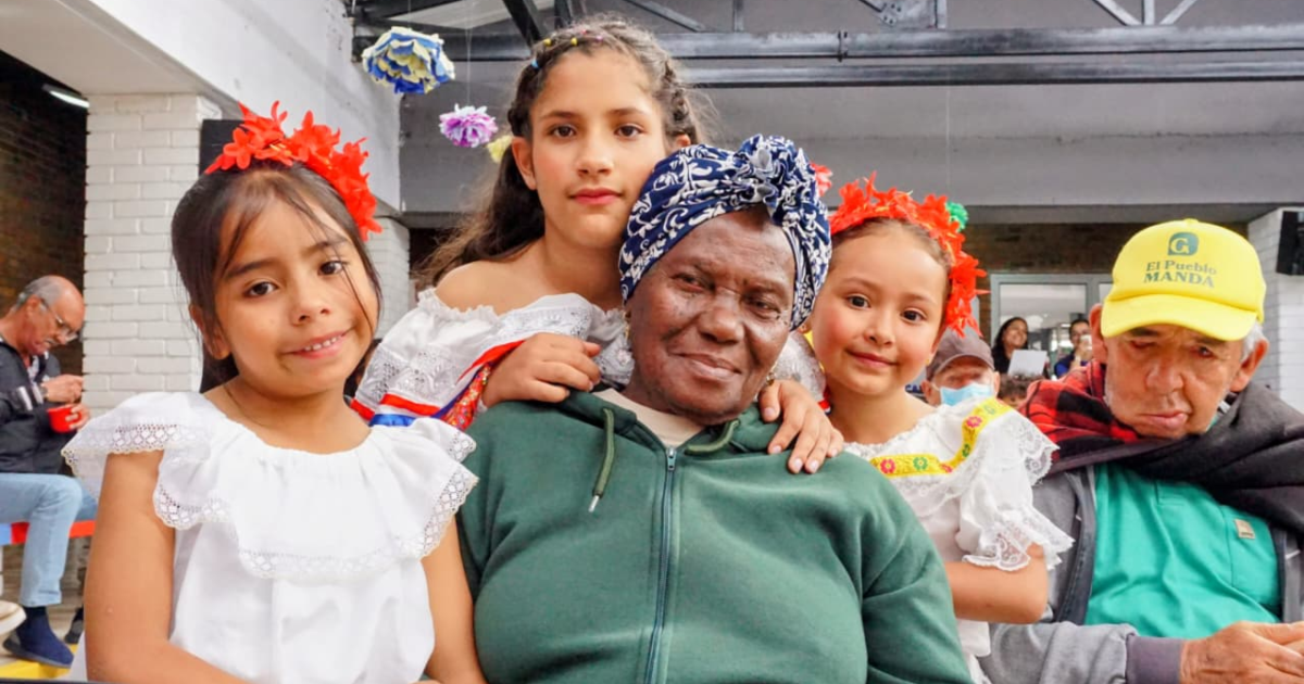 Imagen de una adulta mayor con varios niños y niñas