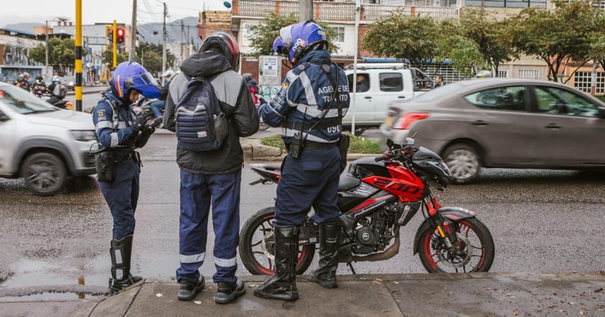 Foto de agentes de tránsito junto a un motociclista en Bogotá