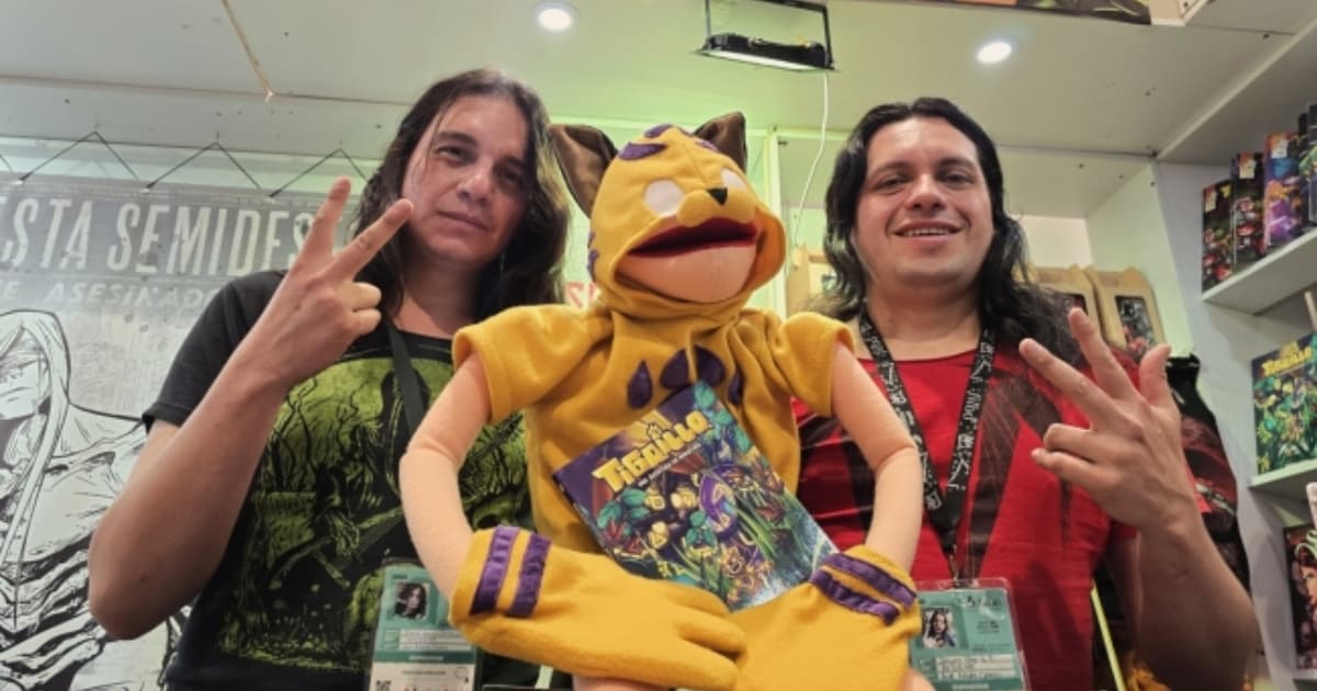 Dos hombres con un títere de un tigrillo.