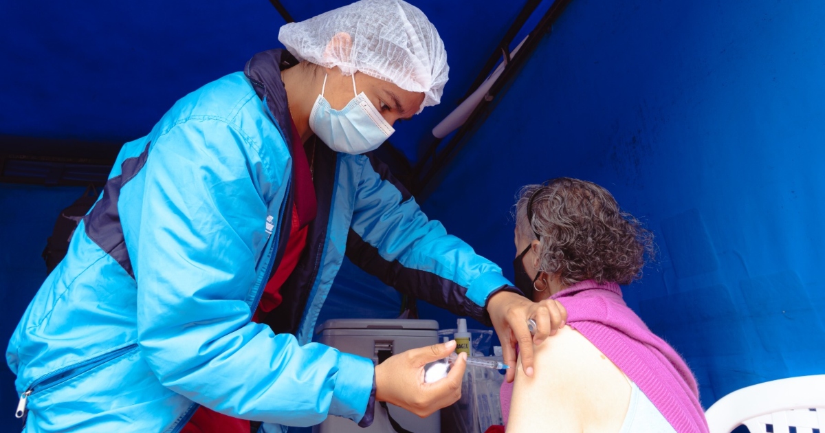 Foto que muestra una persona colocando una vacuna en un brazo 