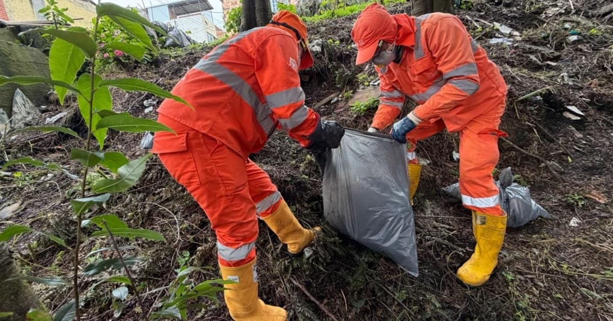 Foto que muestra dos personas con el uniforme de Aguas de Bogotá recogiendo residuos 