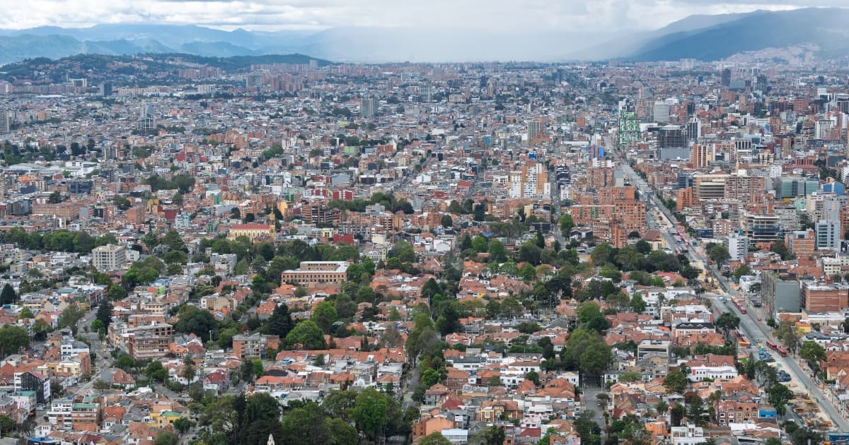Vista panorámica de Bogotá con amplia zona residencial, edificaciones densas, avenidas principales, cerros orientales y cielo nublado asociada al pronóstico del clima.