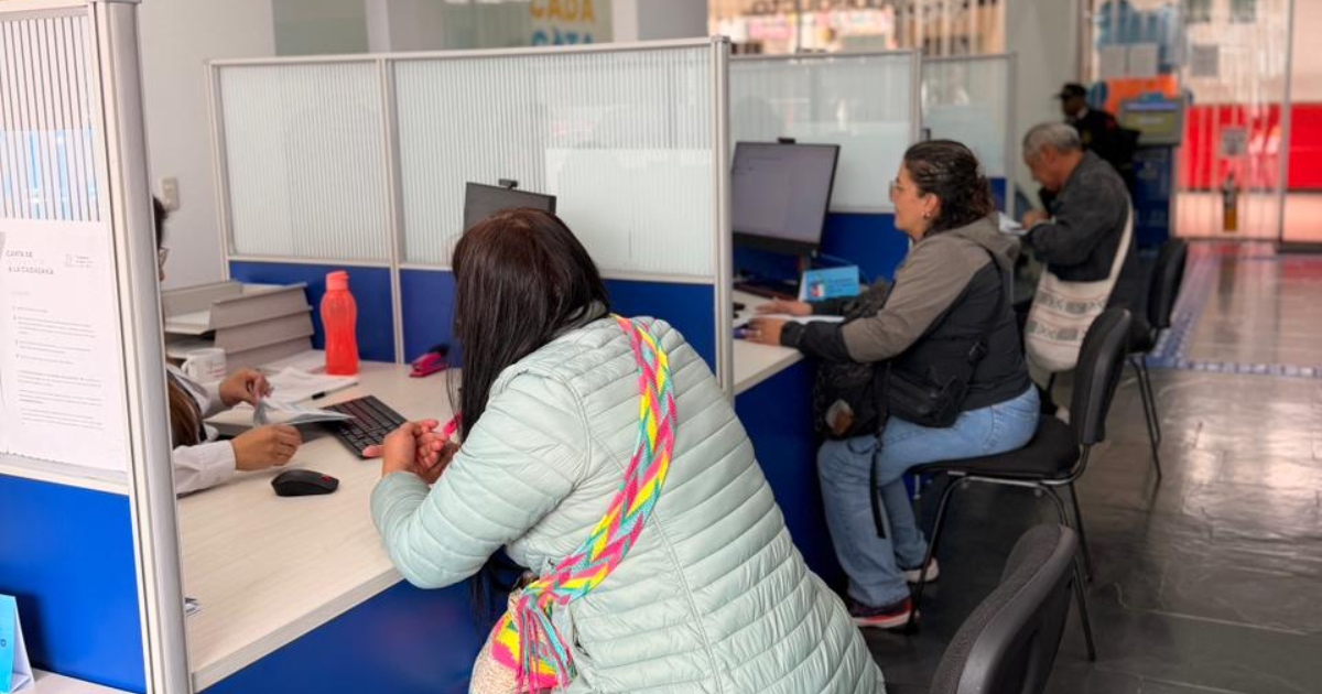 Foto que muestra tres personas sentadas frente a modulos de atención 