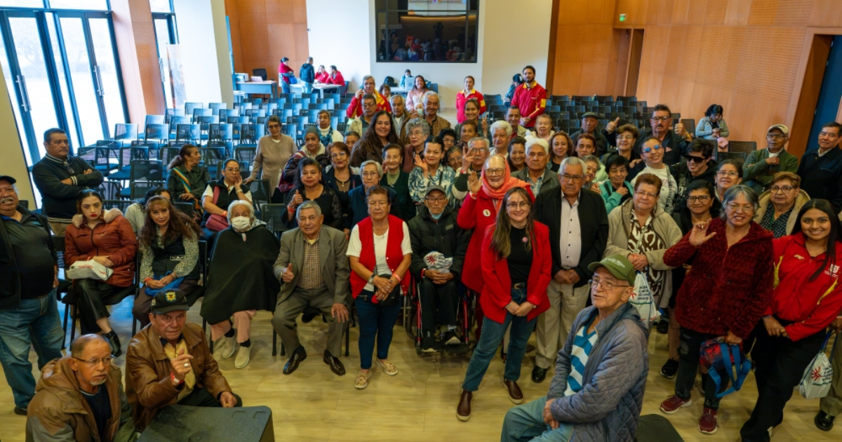 Foto de un grupo de adultos mayores en un auditorio