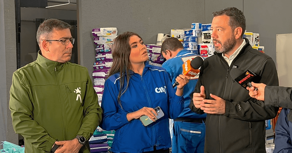Alcalde de Bogotá, Carlos Fernando Galán y el director del IDIGER, Guillermo Escobar, dan declaraciones a medios de comunicación en un centro de acopio con insumos de ayuda humanitaria apilados al fondo para atender a personas afectadas por sismo del lunes 10 de agosto