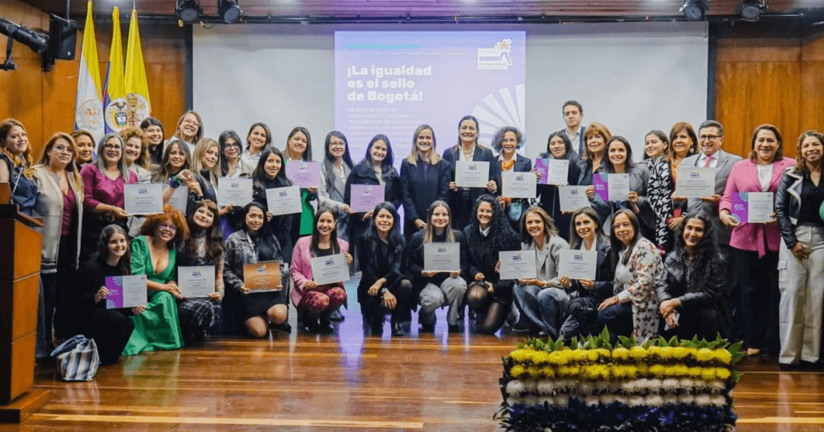 Secretaria de la Mujer, Laura Tami Leal, junto a otras mujeres en un auditorio.