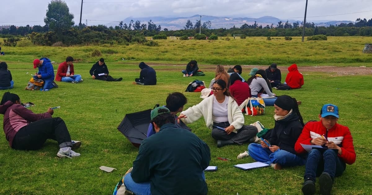 Personas sentadas en un parque analizando ¿Cómo queremos que sea Bogotá en 2038? 