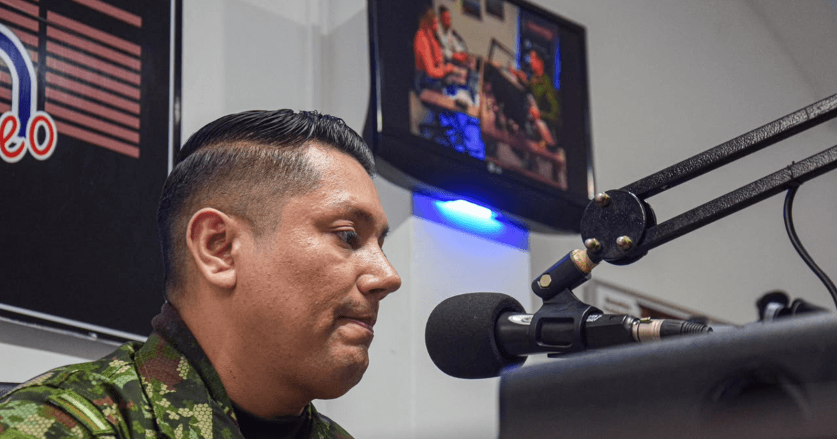 Uniformado del ejército hablando en una cabina de radio.