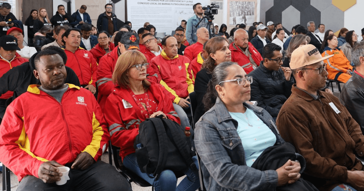 Personas sentadas en filas de sillas durante un encuentro ciudadano en un auditorio.