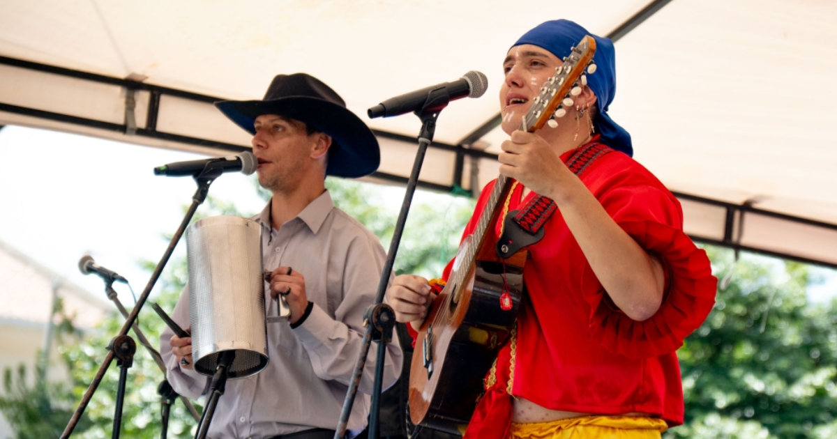 Imagen de dos hombres con trajes típicos tocando música colombiana.