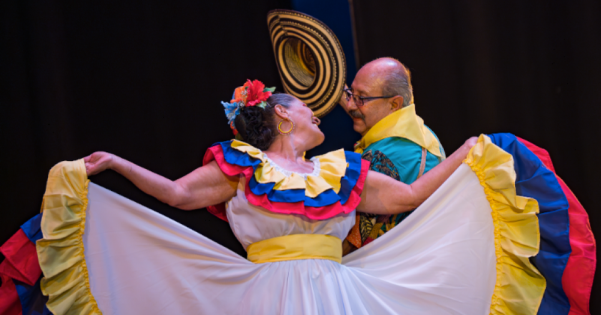 Imagen de un hombre y una mujer mayores bailando cumbia con sus respectivos trajes tipícos.