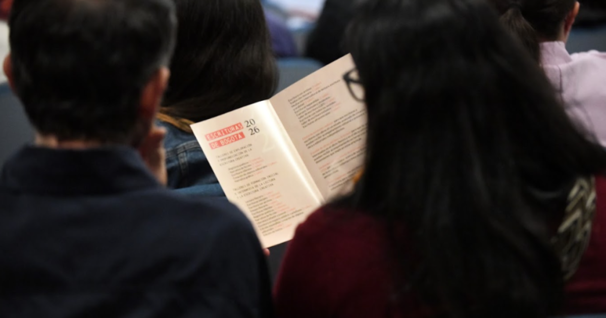 Imagen de personas de espaldas leyendo un folleto de escrituras de Bogotá