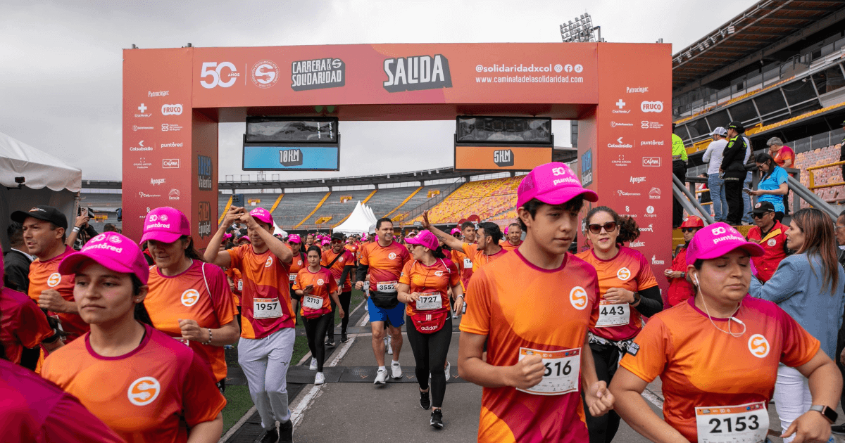 Participantes de la Carrera de la Solidaridad cruzan el punto de salida en el estadio El Campín.