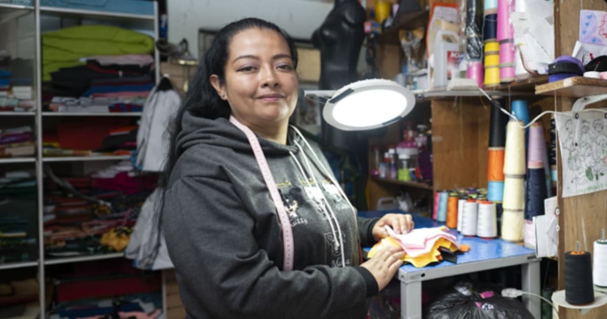 Foto de una mujer en su negocio de textiles en Bogotá.