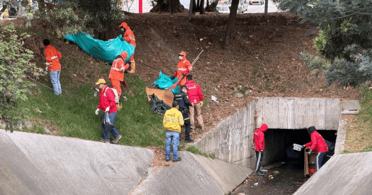 Foto que muestra personas limpiando un canal de agua 