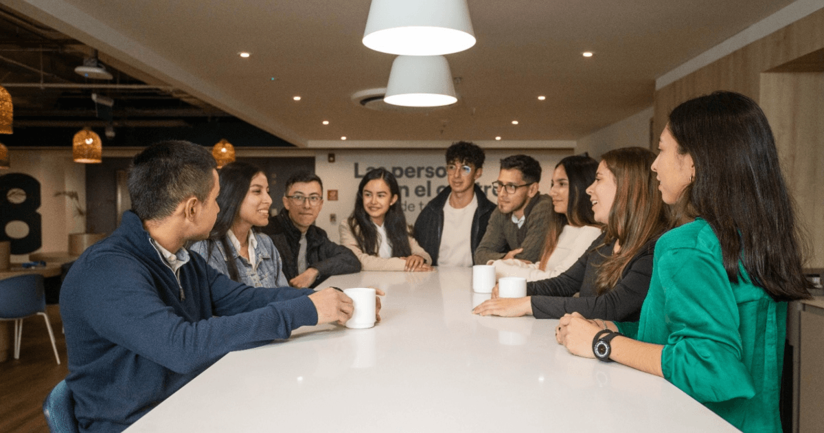 Foto que muestra un grupo de personas sentadas hablando