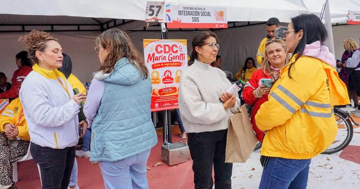 Foto de un grupo de ciudadanos recibiendo asesoría de funcionarios de la Secretaría Distrital de Integración Social en un evento público en una plazoleta de Bogotá.