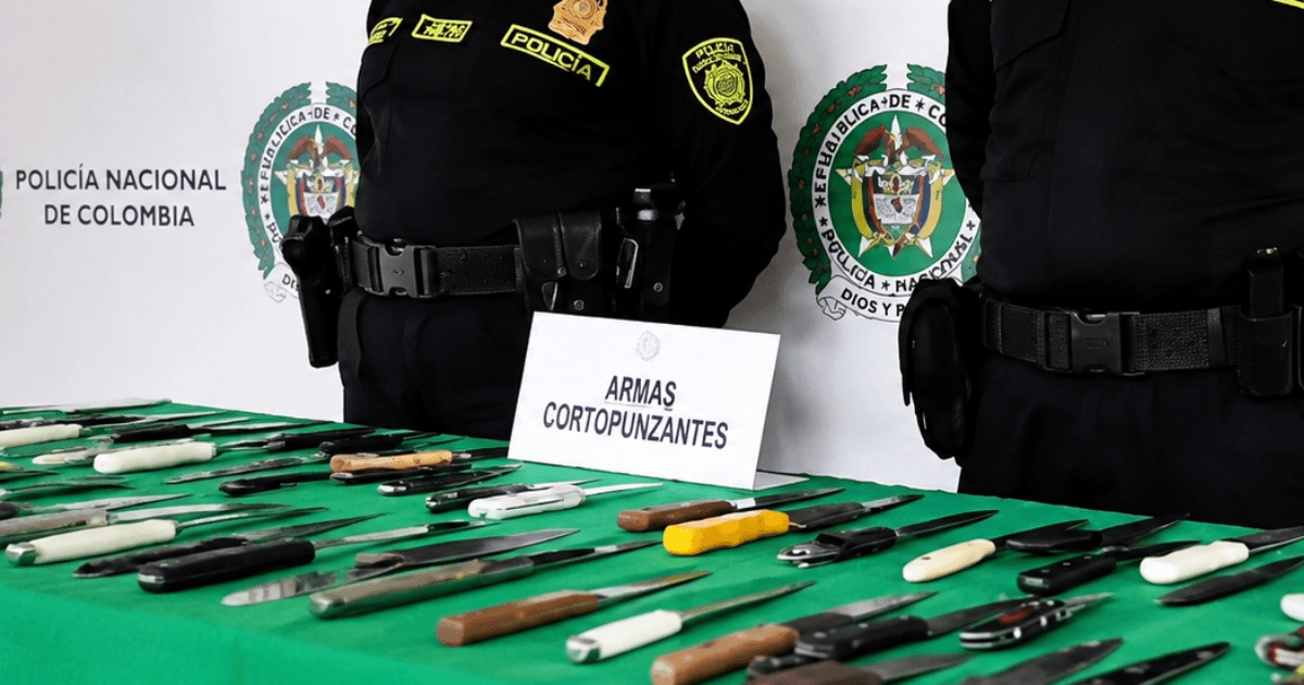 Foto que muestra dos policías y armas cortopunzantes en una mesa